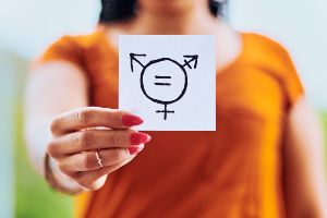 Woman out of focus holding up gender equality sign